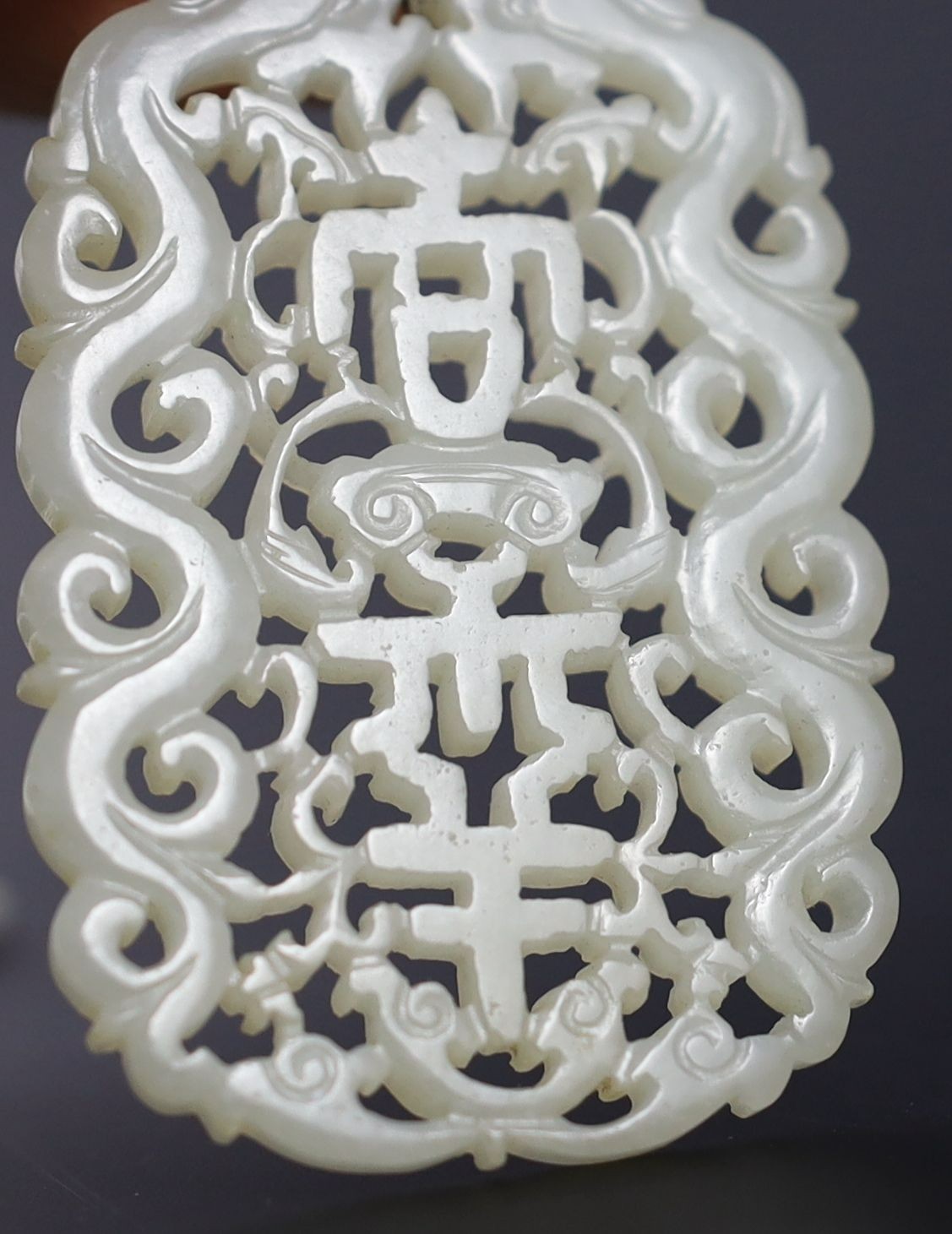 Two Chinese pale celadon jade openwork plaques, 19th century, 5.4 cm and 6.4 cm